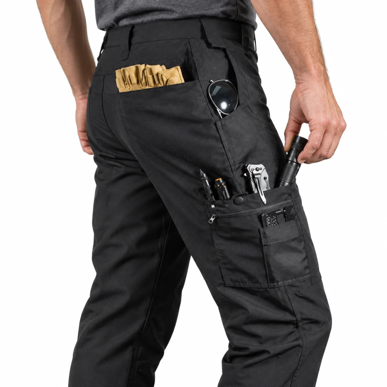 Reaching for gear in the pockets of black Handolf work pants